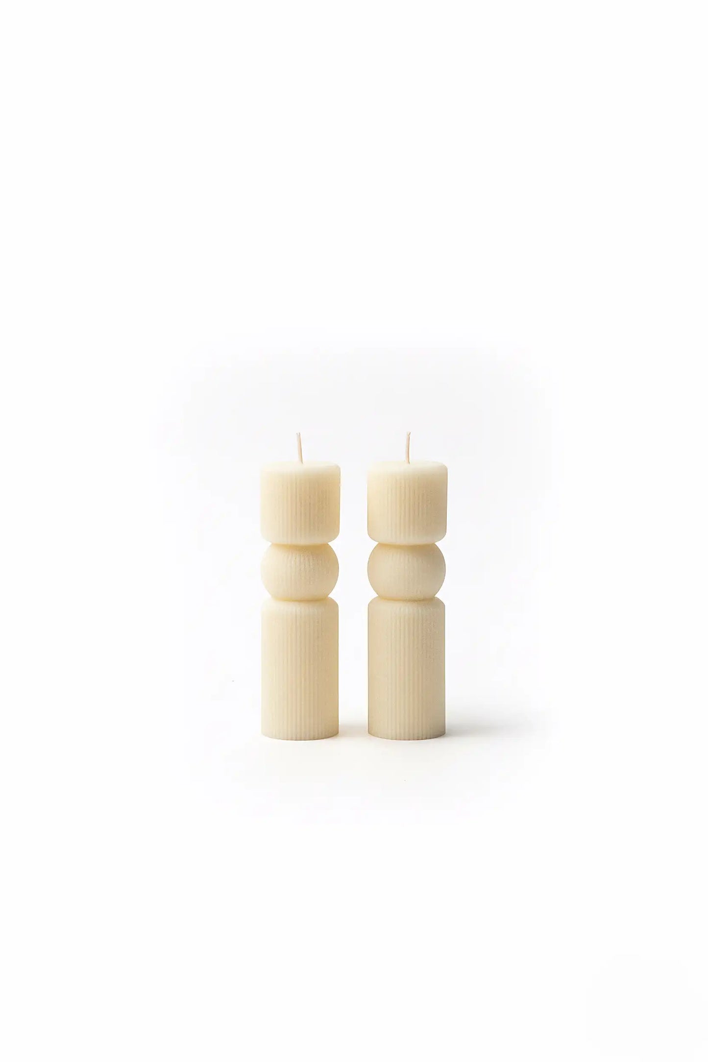 Two WHITE PILLAR candles on a white background