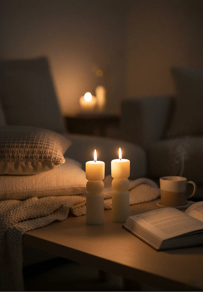 pillar Candlelit scene with a book and mug on a table in a cozy room.