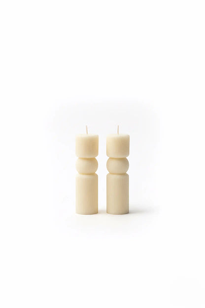 Two WHITE PILLAR candles on a white background