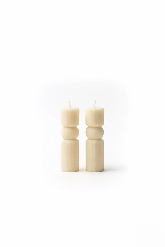 Two WHITE PILLAR candles on a white background